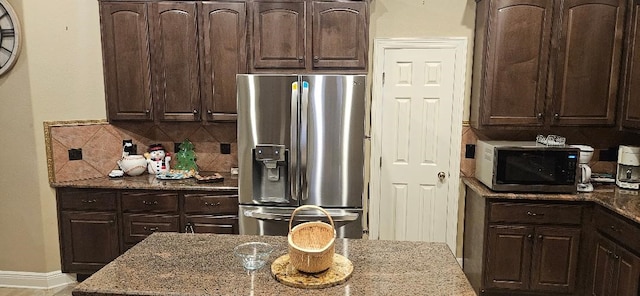 5322 Norborne Ln, Houston, TX 77069 - kitchen with stainless steel appliances, light stone countertops, dark brown cabinetry, and decorative backsplash