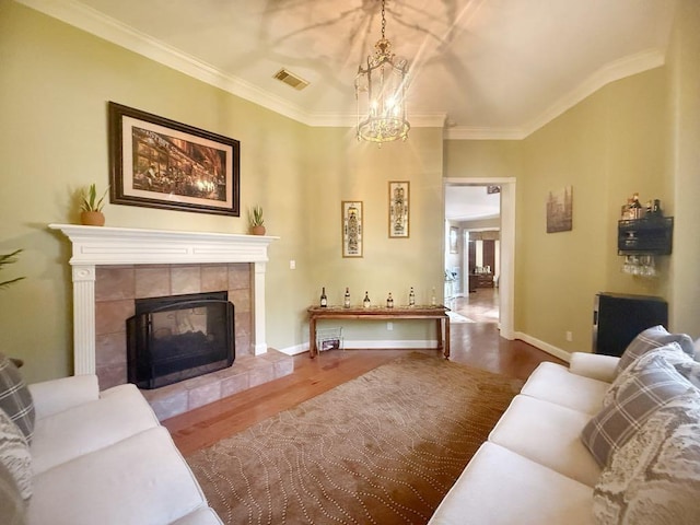 5322 Norborne Ln, Houston, TX 77069 - living room featuring wood finished floors, ornamental molding, a tiled fireplace, and a chandelier