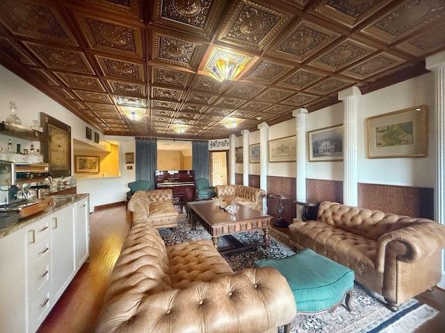 5322 Norborne Ln, Houston, TX 77069 - living room featuring decorative columns, wood finished floors, wainscoting, an ornate ceiling, and bar