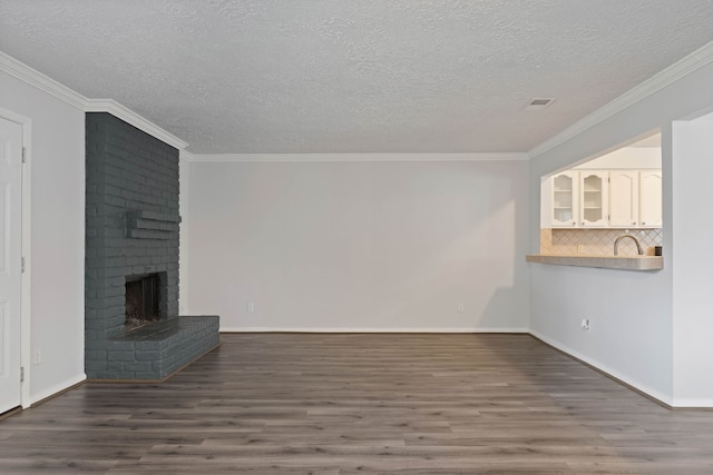 14138 Rosetta Dr, Cypress, TX 77429 - unfurnished living room with wood finished floors, a textured ceiling, a fireplace, and ornamental molding