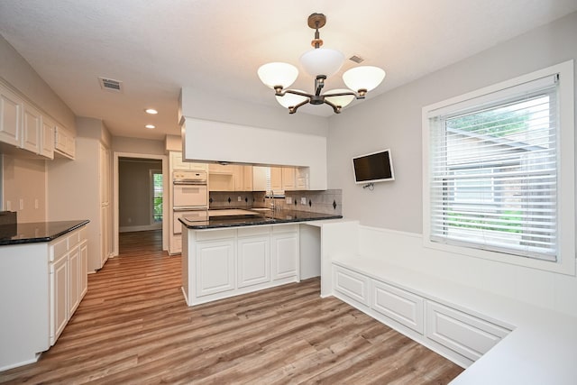 5906 Dumfries Dr, Houston, TX 77096 - kitchen with a chandelier, light wood-style floors, a peninsula, recessed lighting, and decorative backsplash