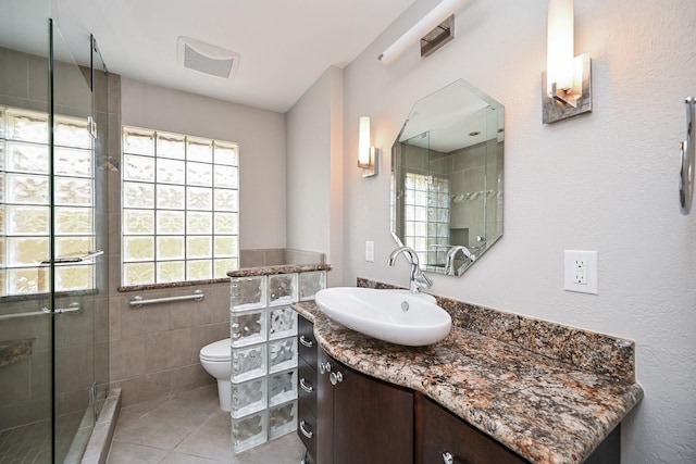 5906 Dumfries Dr, Houston, TX 77096 - full bathroom featuring vanity, a stall shower, tile patterned flooring, and tile walls