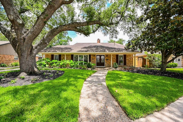 5906 Dumfries Dr, Houston, TX 77096 - ranch-style house featuring a front yard, brick siding, a chimney, and french doors