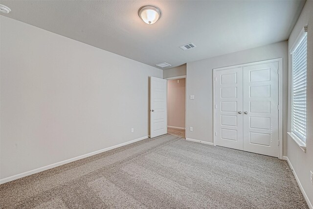 27072 Badger Way, Magnolia, TX 77354 - unfurnished bedroom featuring carpet, multiple windows, and a closet