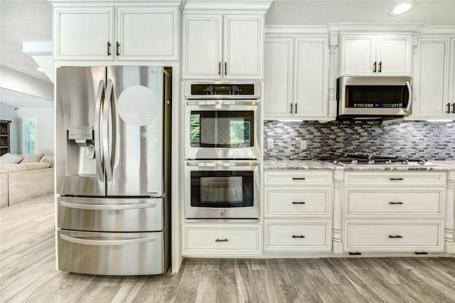 1904 Nursery Rd, The Woodlands, TX 77380 - kitchen with appliances with stainless steel finishes, light stone countertops, tasteful backsplash, light wood-style flooring, and recessed lighting