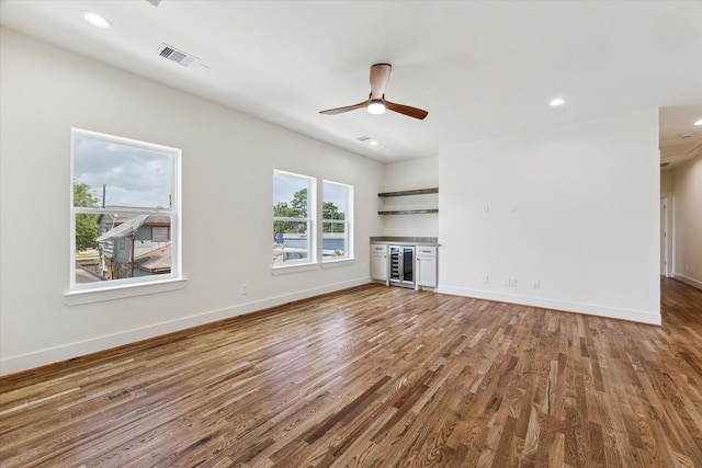 805 English St, Houston, TX 77009 - unfurnished living room featuring beverage cooler, wood finished floors, a ceiling fan, a bar, and recessed lighting