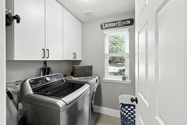 14506 Heron Marsh Dr, Cypress, TX 77429 - laundry room featuring cabinet space, washing machine and dryer, tile patterned floors, and a textured ceiling