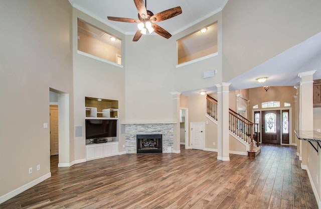 21827 Barton Park Ln, Katy, TX 77450 - unfurnished living room with ceiling fan, a towering ceiling, wood finished floors, stairs, and a stone fireplace