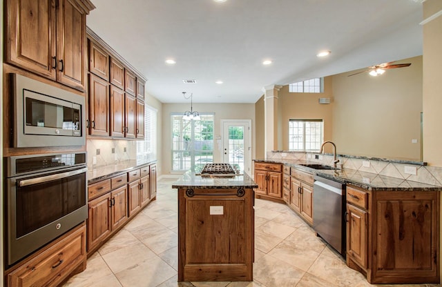 21827 Barton Park Ln, Katy, TX 77450 - kitchen featuring appliances with stainless steel finishes, a kitchen island, tasteful backsplash, dark stone counters, and a ceiling fan