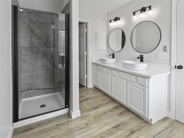 5031 Rustling Branch Ln, Katy, TX 77449 - bathroom featuring double vanity, a stall shower, and wood finished floors