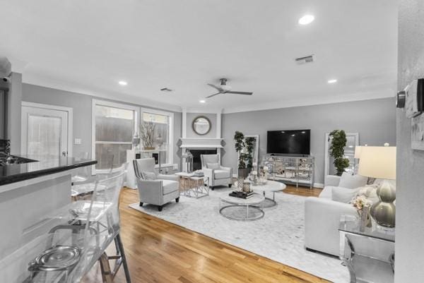 5603 Dolores St, Houston, TX 77057 - living area with a ceiling fan, a fireplace, wood finished floors, recessed lighting, and ornamental molding