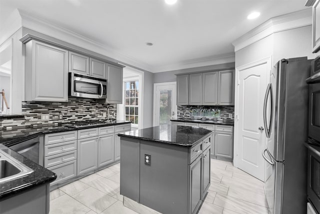 5603 Dolores St, Houston, TX 77057 - kitchen featuring appliances with stainless steel finishes, gray cabinets, a center island, backsplash, and crown molding