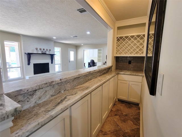 711 Holly Springs Dr, Conroe, TX 77302 - kitchen featuring a fireplace, light stone countertops, backsplash, dark stone finish flooring, and recessed lighting