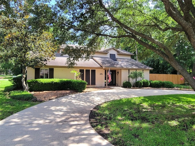 711 Holly Springs Dr, Conroe, TX 77302 - view of front of house with roof with shingles, brick siding, and curved driveway