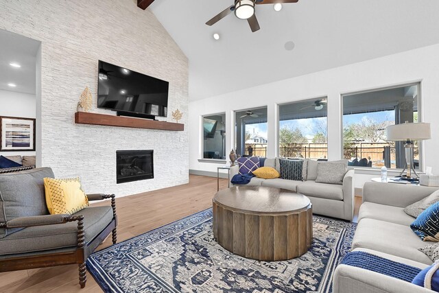 10102 Hooke Dr, Iowa Colony, TX 77583 - living room featuring a ceiling fan, wood finished floors, high vaulted ceiling, a fireplace, and beamed ceiling
