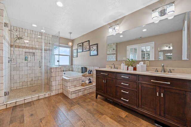 11320 Cedar Gully Rd, Beach City, TX 77523 - bathroom with double vanity, a garden tub, a shower stall, wood-type flooring, and recessed lighting