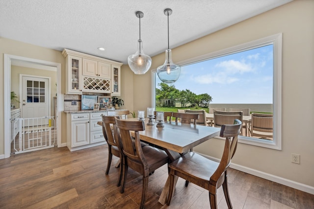 11320 Cedar Gully Rd, Beach City, TX 77523 - dining space featuring wood finished floors, a textured ceiling, recessed lighting, and bar