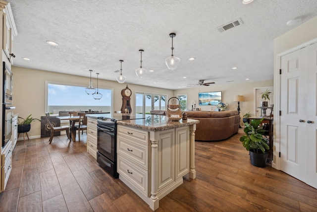 11320 Cedar Gully Rd, Beach City, TX 77523 - kitchen with black electric range oven, cream cabinets, a textured ceiling, recessed lighting, and dark wood-style floors