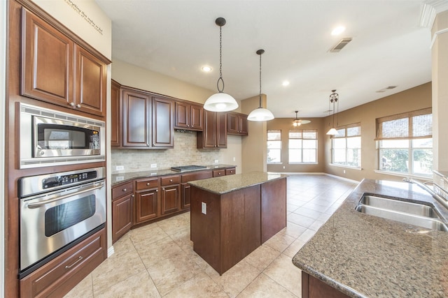 18219 S Austin Shore Dr, Cypress, TX 77433 - kitchen with stainless steel appliances, a kitchen island, decorative backsplash, light tile patterned flooring, and decorative light fixtures