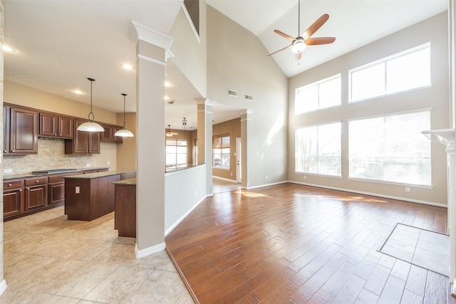 18219 S Austin Shore Dr, Cypress, TX 77433 - kitchen featuring ornate columns, a ceiling fan, a center island, open floor plan, and stainless steel gas stovetop