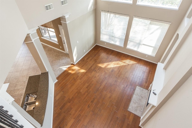 18219 S Austin Shore Dr, Cypress, TX 77433 - unfurnished living room with hardwood / wood-style floors, stairs, and a high ceiling