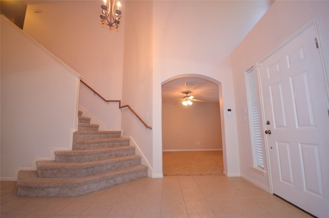 6906 Grant Dr, Magnolia, TX 77354 - carpeted entrance foyer with arched walkways, stairway, tile patterned flooring, and ceiling fan