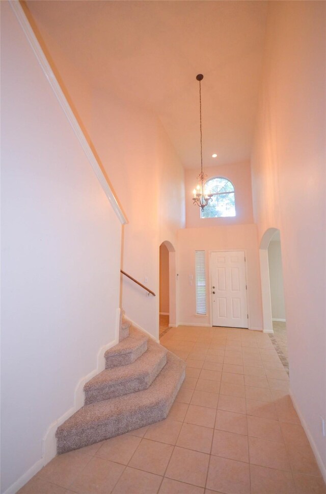 6906 Grant Dr, Magnolia, TX 77354 - foyer with arched walkways, a chandelier, stairway, a high ceiling, and light tile patterned floors