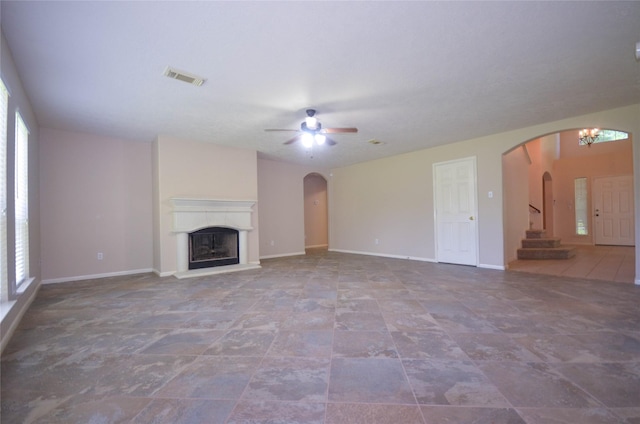 6906 Grant Dr, Magnolia, TX 77354 - unfurnished living room with arched walkways, a ceiling fan, and plenty of natural light