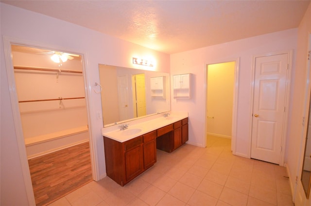 6906 Grant Dr, Magnolia, TX 77354 - bathroom with double vanity, tile patterned flooring, a spacious closet, and ceiling fan