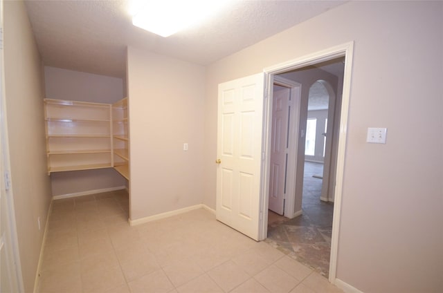 6906 Grant Dr, Magnolia, TX 77354 - corridor with a textured ceiling and light tile patterned floors