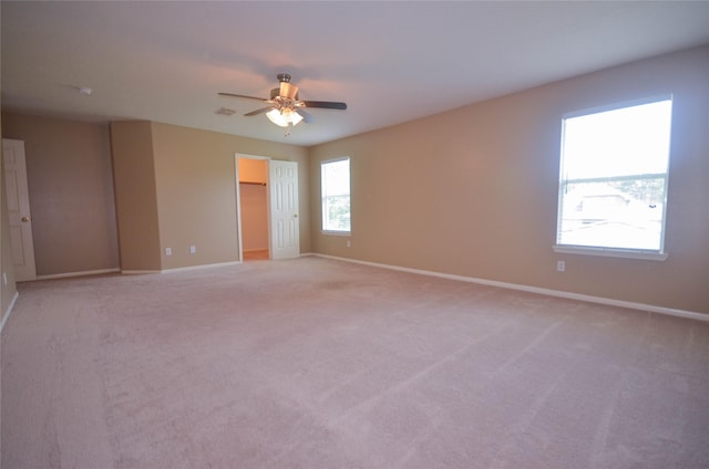 6906 Grant Dr, Magnolia, TX 77354 - unfurnished bedroom with a spacious closet, light carpet, ceiling fan, and a closet