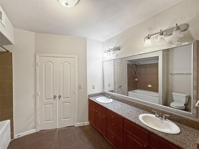 1711 Old Spanish Trl Unit 240, Houston, TX 77054 - bathroom featuring shower / bathtub combination, double vanity, tile patterned flooring, and a textured ceiling