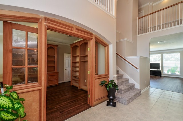 1501 Mulberry Ct, Pearland, TX 77581 - stairway featuring ornamental molding, wood finished floors, arched walkways, and a towering ceiling