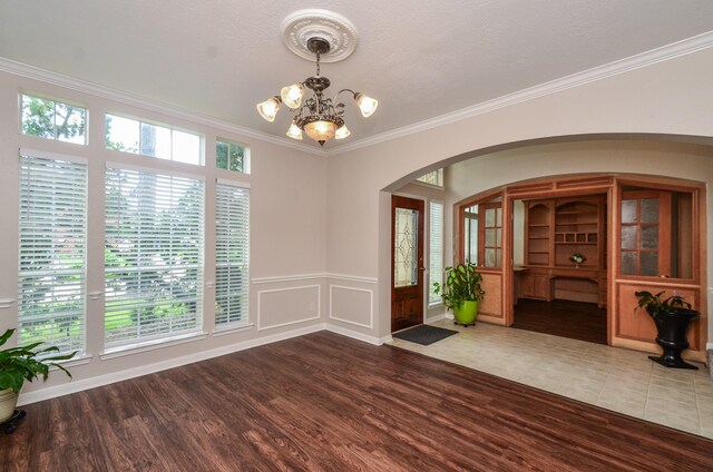 1501 Mulberry Ct, Pearland, TX 77581 - entrance foyer with arched walkways, a chandelier, wood finished floors, and crown molding
