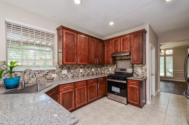 1501 Mulberry Ct, Pearland, TX 77581 - kitchen featuring stainless steel gas range, under cabinet range hood, tasteful backsplash, light tile patterned floors, and recessed lighting