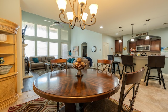 14907 Ashley Creek Ct, Humble, TX 77396 - dining area featuring light tile patterned flooring, ceiling fan, a chandelier, recessed lighting, and arched walkways