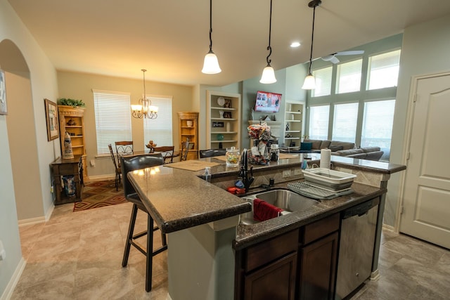 14907 Ashley Creek Ct, Humble, TX 77396 - kitchen featuring dishwasher, dark brown cabinets, a center island with sink, arched walkways, and a kitchen bar