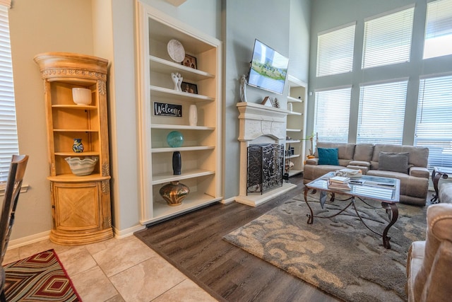 14907 Ashley Creek Ct, Humble, TX 77396 - living room featuring a fireplace with raised hearth, a towering ceiling, tile patterned flooring, and built in shelves