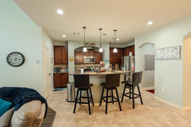 14907 Ashley Creek Ct, Humble, TX 77396 - kitchen with appliances with stainless steel finishes, a breakfast bar, decorative backsplash, recessed lighting, and open floor plan