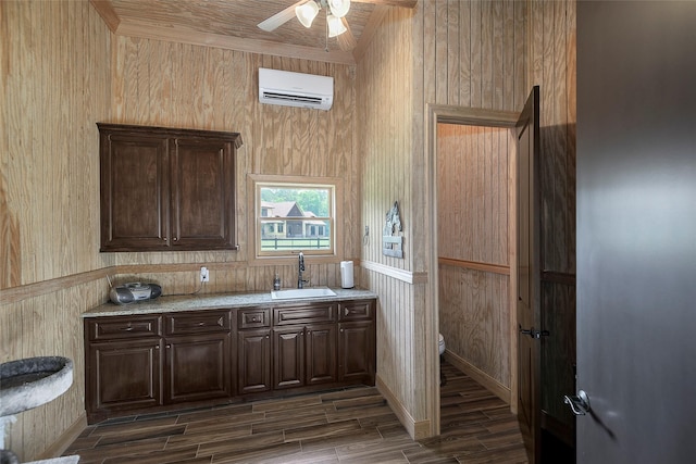 42015 Mill Creek Rd, Magnolia, TX 77354 - kitchen featuring an AC wall unit, dark brown cabinets, a ceiling fan, wood walls, and dark wood-type flooring