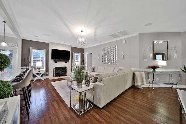 27115 Meadow Sage Ct, Cypress, TX 77433 - living room featuring dark wood-style flooring, a fireplace, ornamental molding, and a chandelier