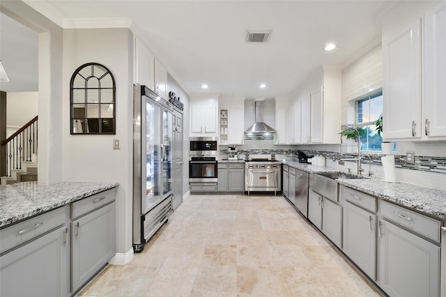 27115 Meadow Sage Ct, Cypress, TX 77433 - kitchen with premium appliances, wall chimney range hood, decorative backsplash, light stone countertops, and recessed lighting