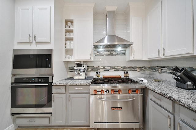 27115 Meadow Sage Ct, Cypress, TX 77433 - kitchen with appliances with stainless steel finishes, wall chimney exhaust hood, tasteful backsplash, white cabinets, and ornamental molding