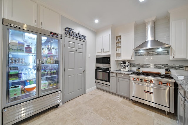 27115 Meadow Sage Ct, Cypress, TX 77433 - kitchen with appliances with stainless steel finishes, wall chimney exhaust hood, a warming drawer, decorative backsplash, and light stone countertops