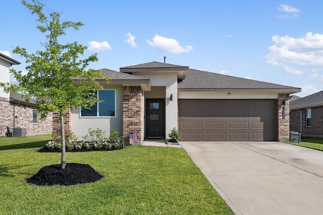 14906 Rain Tree Dr, Baytown, TX 77523 - prairie-style house with an attached garage, concrete driveway, a front lawn, stucco siding, and brick siding