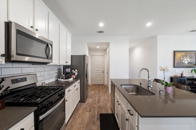 14906 Rain Tree Dr, Baytown, TX 77523 - kitchen featuring stainless steel appliances, dark countertops, a center island with sink, backsplash, and recessed lighting