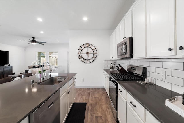 14906 Rain Tree Dr, Baytown, TX 77523 - kitchen featuring stainless steel appliances, dark countertops, backsplash, recessed lighting, and white cabinets