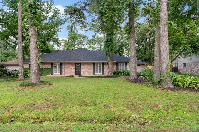 25607 Spring Ridge Dr, Spring, TX 77386 - single story home featuring a front yard, brick siding, a garage, and roof with shingles