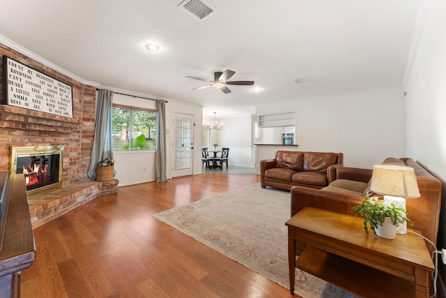 25607 Spring Ridge Dr, Spring, TX 77386 - living room featuring crown molding, ceiling fan, a brick fireplace, wood finished floors, and recessed lighting