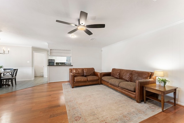 25607 Spring Ridge Dr, Spring, TX 77386 - living area with light wood-style flooring, a ceiling fan, crown molding, and a chandelier